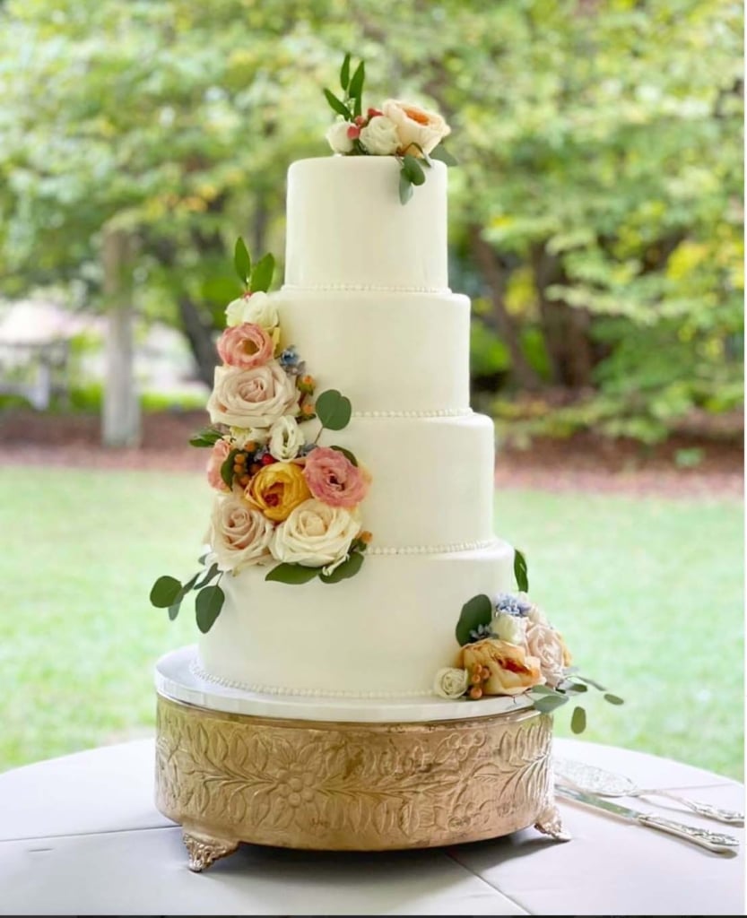 white wedding cake with ivory and pink flowers