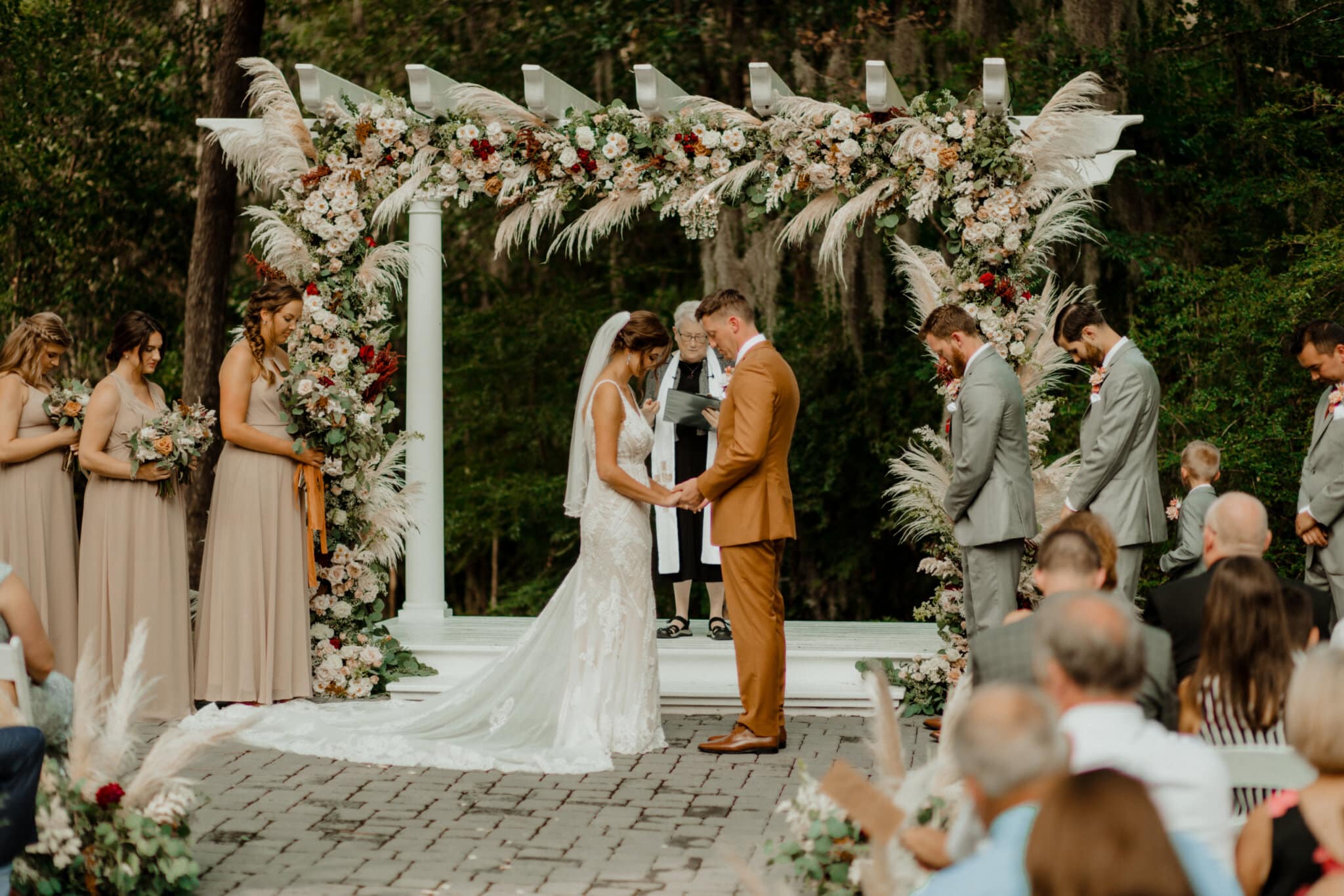 a couple during their wedding ceremony in the georgia garden at the mackey house in savannah, ga